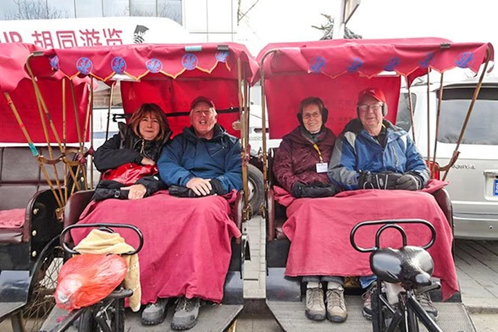 Travelers enjoying a rickshaw ride through Beijing hutongs